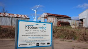 Hepburn wind sign with sheds and wind turbines in background