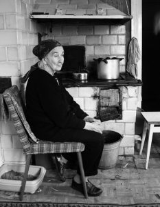 Woman sitting on front of a wood stove