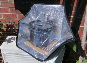 Solar oven in sun with black bucket inside