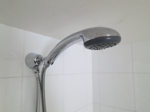 Water saving shower head installed in shower cubicle