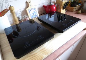 Portable induction hotplates on kitchen bench made to cover existing gas stovetop