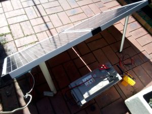 Solar panel and a deep cycle battery in a courtyard 