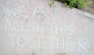 "We are all in this together" written on a wall in a public place.